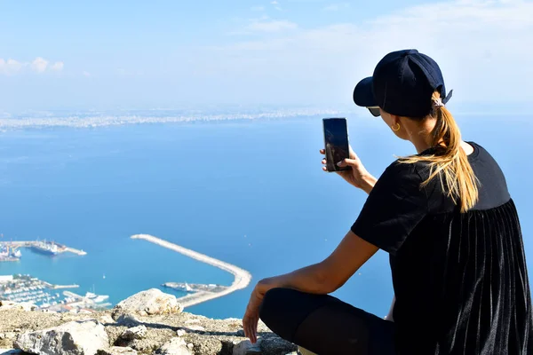 Nő turista néz a városra a hegyről. — Stock Fotó