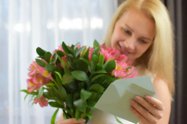 Mujer sosteniendo ramo de flores en las manos en la habitación. mujer feliz en casa con flores. — Foto de Stock