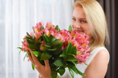 Pembe buket taze bahar çiçekleri ve aşık genç bir kadın..