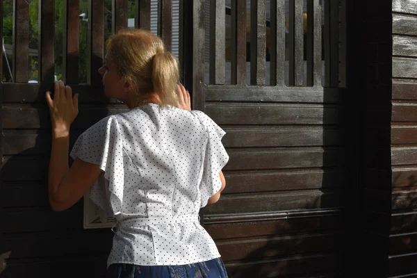 Ein junges Mädchen tritt die Außentür zum Hof ein, Rückansicht. — Stockfoto