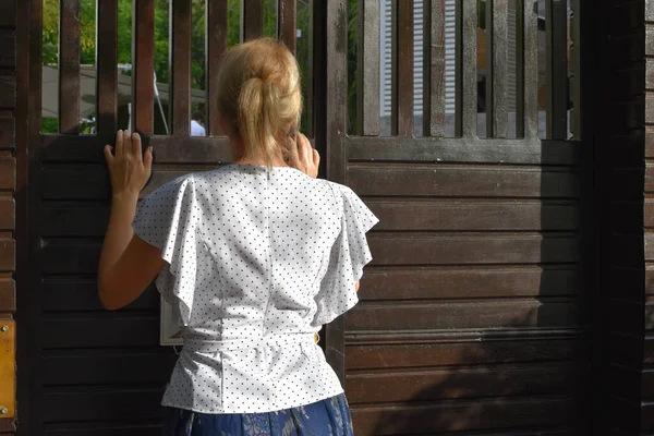 Ein junges Mädchen tritt die Außentür zum Hof ein, Rückansicht. — Stockfoto