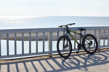 Bisikletli turist sahil boyunca yürüyor. Deniz kıyısında bisiklet turu.