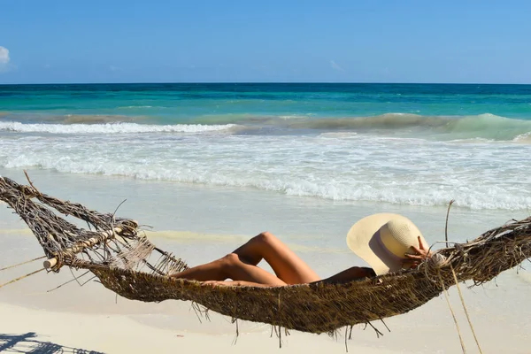 Una donna in costume da bagno prende il sole su un'amaca su una spiaggia tropicale. — Foto Stock