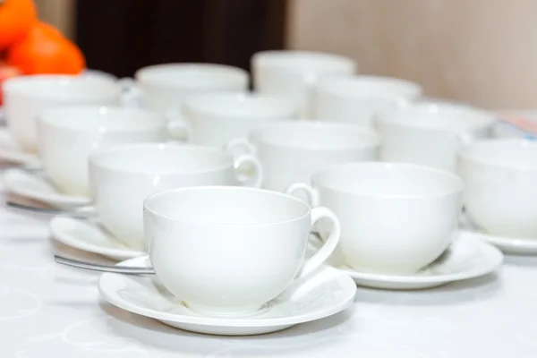 Diverse tazze di caffè bianco su un banchetto — Foto Stock