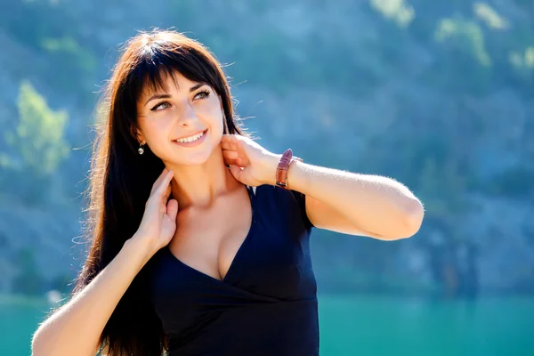 Retrato de una hermosa niña sobre un fondo de montañas y t — Foto de Stock