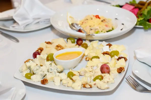 Plátkový Sýr Hrozny Zlato Bílé Plotně Dovolenou Stůl Restauraci — Stock fotografie