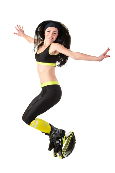 Brunette meisje glimlachend met lange haren springen in een kangoo jumps Stockfoto