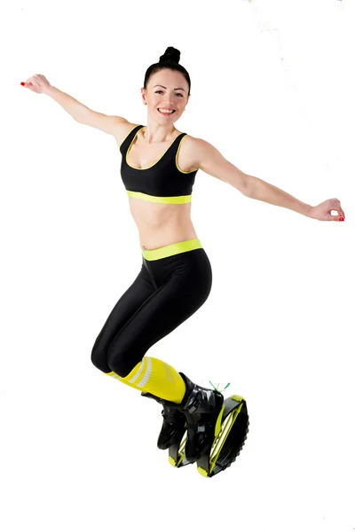 Lächelndes brünettes Mädchen springt in einem Kangoo springt Schuhe. — Stockfoto