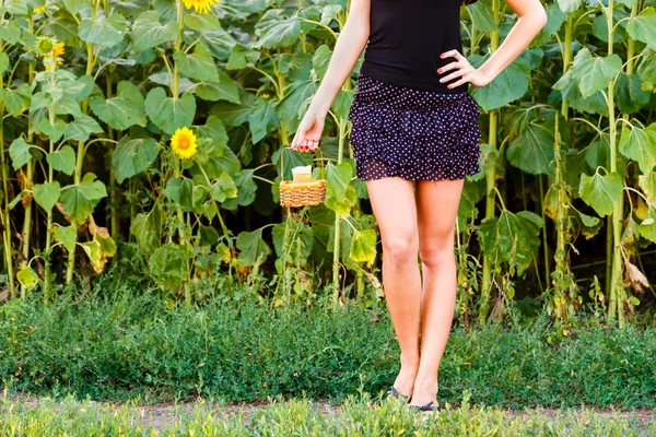 Young woman holding a wicker basket with a jug of sunflower oil — Stock Photo, Image