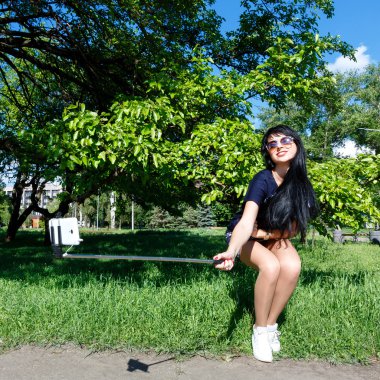 Neşeli esmer kız selfie Fotoğraflar telefon ve mono kullanarak yapar