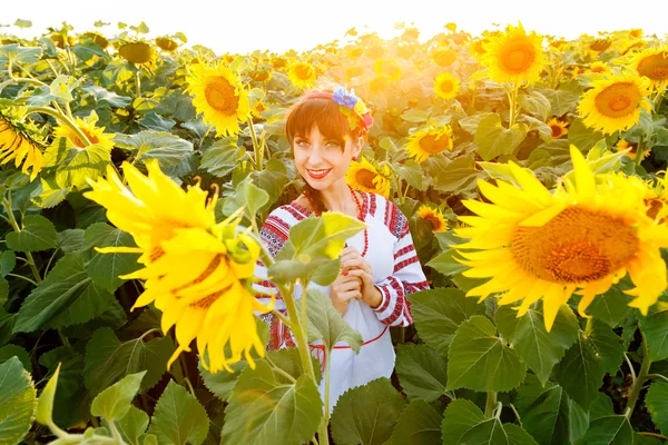Cute young girl in embrodery on a sunflower field Royalty Free Stock Images