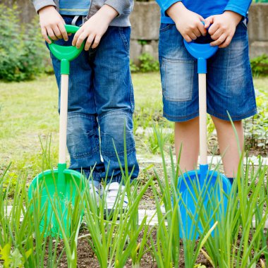 İki erkek ile plastik kürek bahçede oynarken