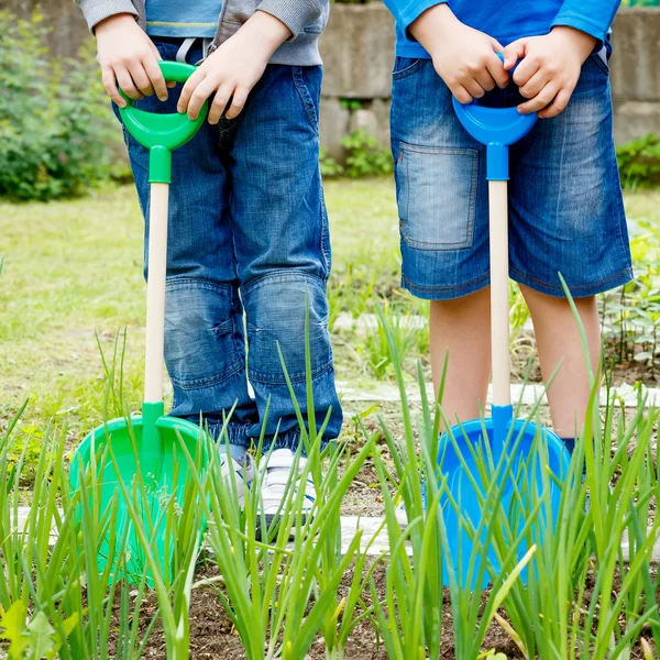 İki erkek ile plastik kürek bahçede oynarken