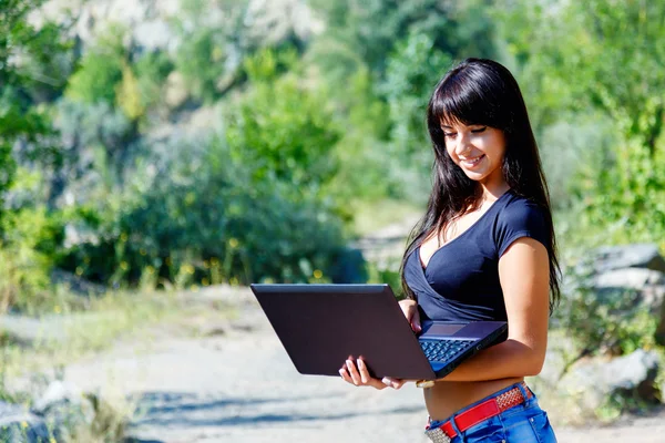 Güzel gülümseyen genç İspanyol kadın laptop açık çalışma — Stok fotoğraf