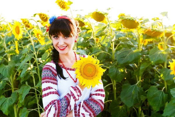 Красива усміхнена жінка в емблемі, що тримає соняшник — стокове фото