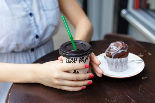 年轻女子在户外咖啡馆里喝咖啡和松饼 — 图库照片