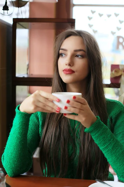 Pensativo hermosa mujer joven bebiendo té en la cafetería — Foto de Stock