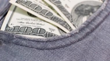 100 dolarlık 3 Amerikan banknotunu dönen masanın üzerindeki kot pantolonun cebinde. Aşırı yakın plan, Yüzeyin Sığ Derinliği. İş konsepti.