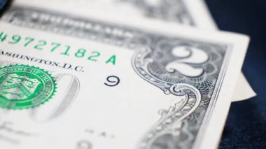 2 ve 1 Amerikan Doları banknotları dönen masanın üzerindeki kot pantolonun cebinde. Aşırı yakın plan, Yüzeyin Sığ Derinliği. İş konsepti, 21 numara...