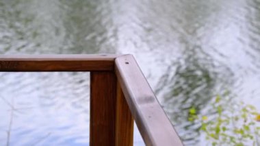 Nehir kenarındaki boş köprünün ahşap korkulukları. Güzel sakin bir yaz gününde huzur. Kimse yok..