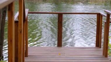 Nehir kenarındaki boş köprünün ahşap korkulukları. Güzel sakin bir yaz gününde huzur. Kimse yok..