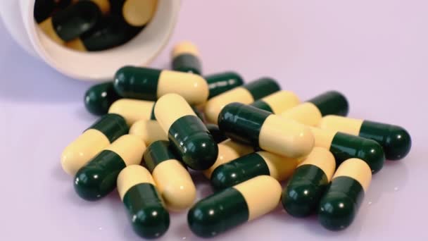 在旋转桌子上的黄绿色胶囊中的大量医疗药丸 维生素 药物的近距离观察 — 图库视频影像