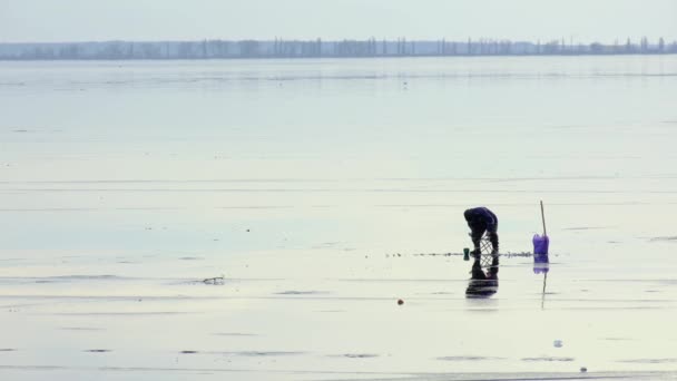 Hombre solo pescando en el río congelado en el día de invierno — Vídeo de stock