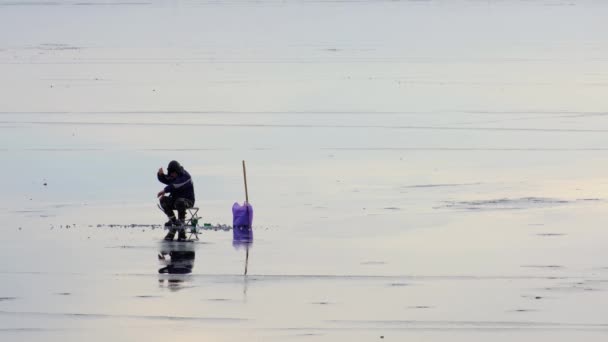 Seul homme pêchant sur la rivière gelée le jour d'hiver — Video