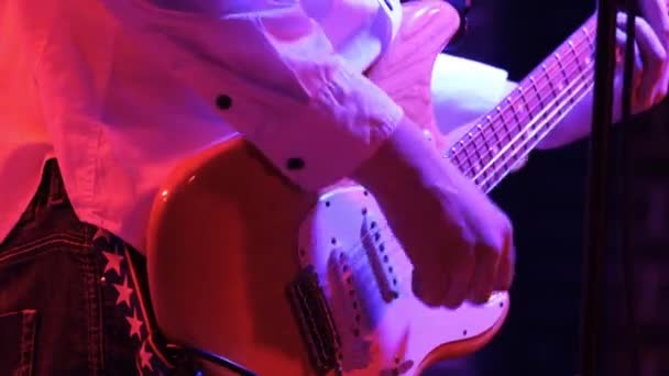 Hombre guitarrista rítmico tocando la guitarra eléctrica en un concierto de rock en un club. — Vídeo de stock
