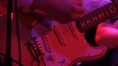 Bir kulüpteki rock konserinde elektro gitar çalan bir adam ritmi gitaristi..
