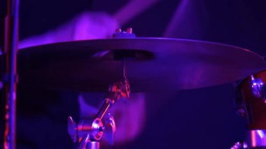 Bir kulüpteki rock konserinde davul çalan adam. Kırmızı ışık, yakın plan..