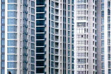 Yeni bir apartmanın ön cephesindeki birçok pencereyi kapatın. Arkaplan için.