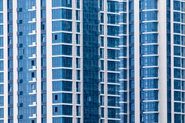 Yeni apartmanın mavi dış tarafındaki birçok pencereyi kapatın. Arkaplan için.