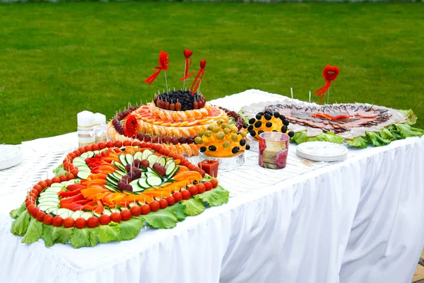 Bankiet stole ozdobionym serca owoców i kiełbaski — Zdjęcie stockowe