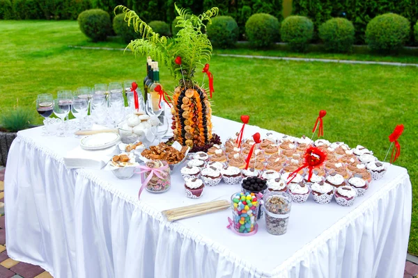 Muffinit sydämet, makeiset, hedelmät ja viiniköynnöksen juhla tabl — kuvapankkivalokuva