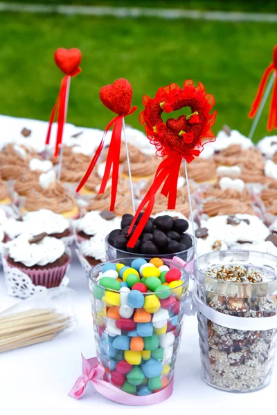 Colorful sweets with hearts on the banquet table — Stock Photo, Image