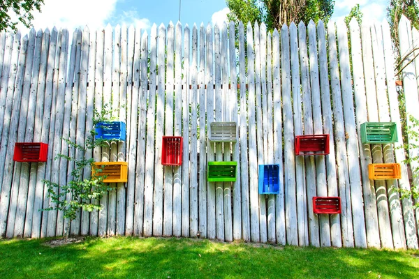 Cajas de colores en una cerca de madera blanca — Foto de Stock