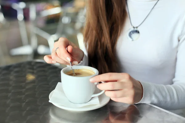 Vrouwelijke handen geroerd de koffie in de cup — Stockfoto