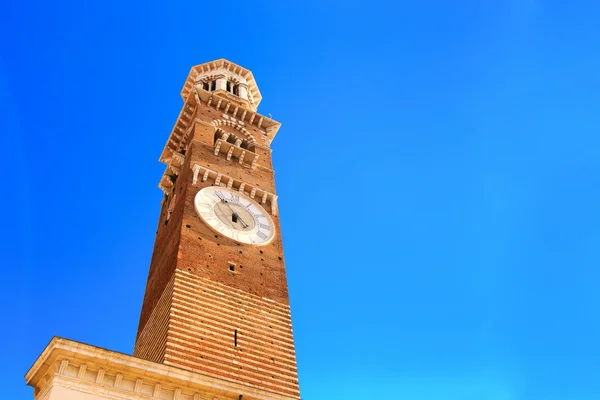 Oude toren met klok op een blauwe hemelachtergrond — Stockfoto