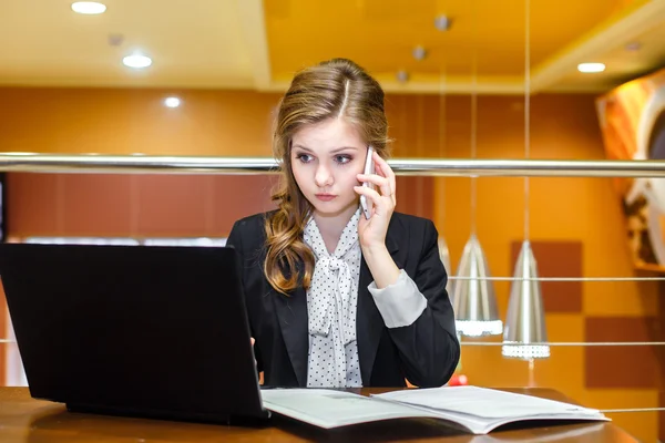 Jóvenes empresarias sentadas en un café con un portátil y hablando —  Fotos de Stock