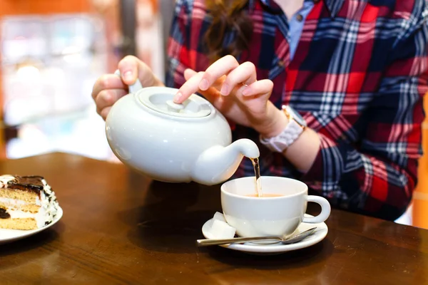 Vrouwelijke handen goot groene thee close-up — Stockfoto