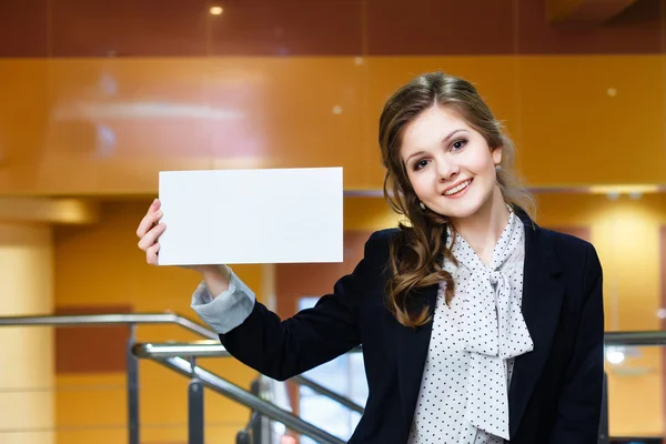 Joven hermosa chica sosteniendo vacío tarjeta blanca y sonriendo — Foto de Stock