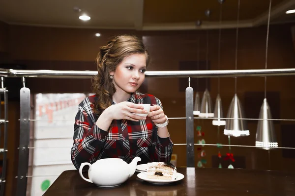 Młode kobiety w plaid shirt picia herbaty w kawiarni — Zdjęcie stockowe