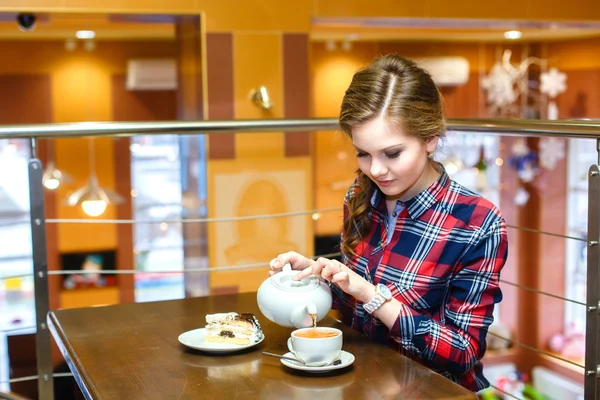 Young women in a plaid shirt pours green tea — Stock Photo, Image