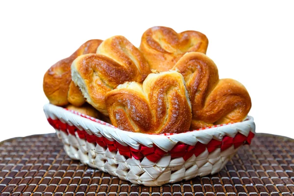 Verse zelfgemaakte broodjes in een mand op een bamboe-lade op een witte achterzijde — Stockfoto