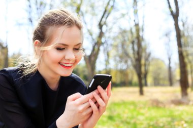 Smartphone gülümseyen içine bakarak dağınık saçlı kadın
