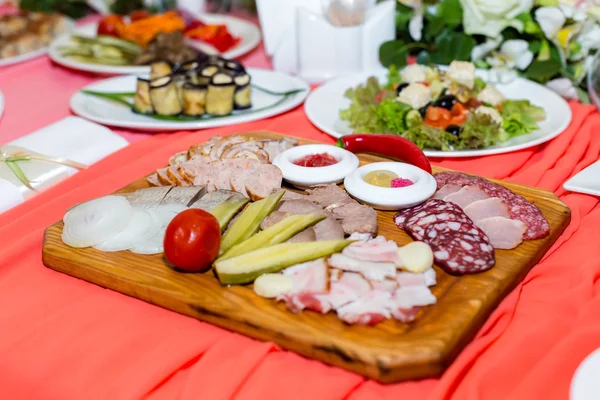 Taglio di carne su piatto di legno su tavolo da banchetto — Foto Stock