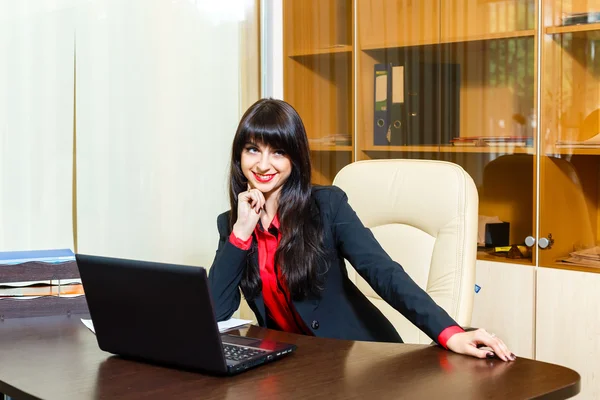 Mujeres de negocios sonrientes sentadas a la mesa en la oficina con la — Foto de Stock