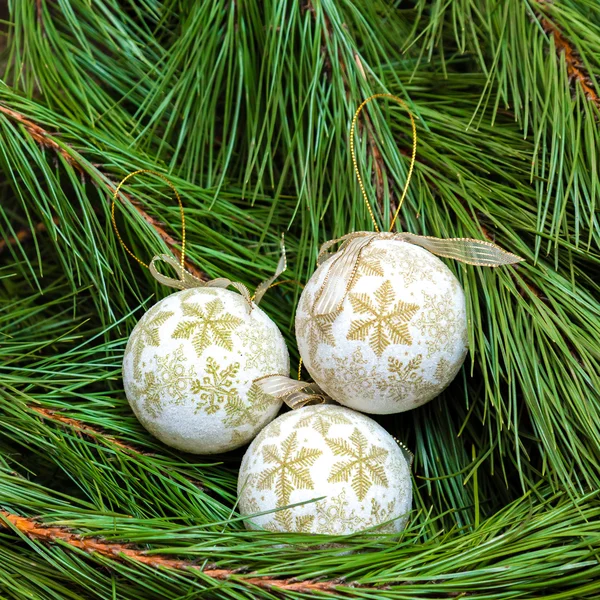 Drie witte kerstballen op een kerstboom — Stockfoto