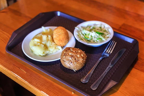 Řízek, brambory, salát a buchta na panelu v kavárně — Stock fotografie